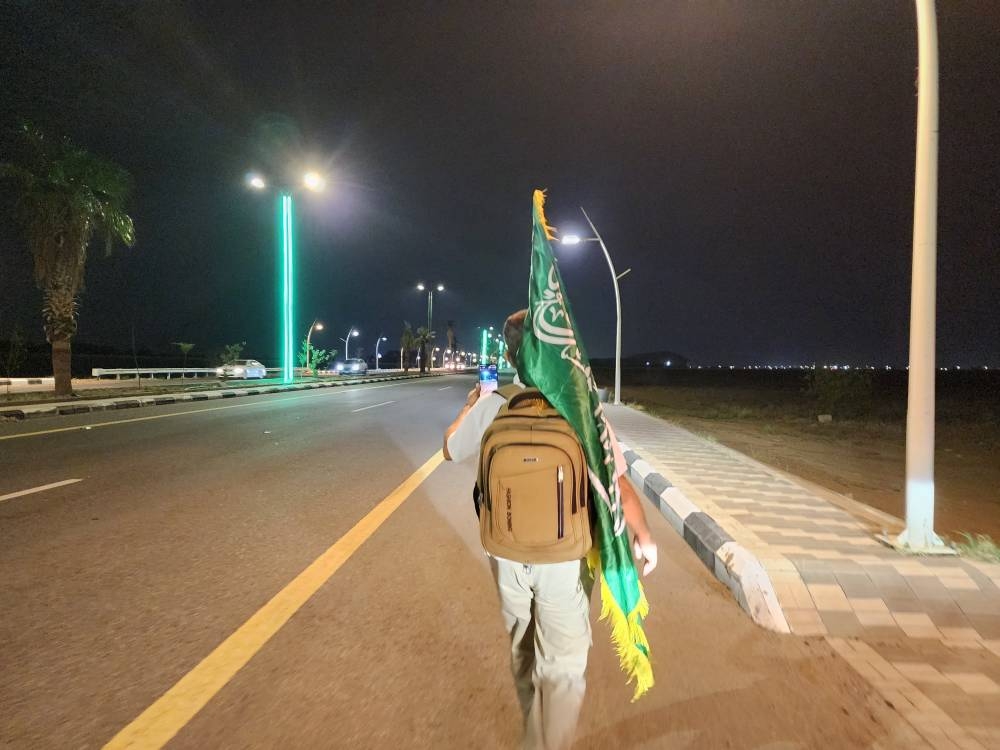 13 عاما يمشي بالعلم احتفاء بالوطن