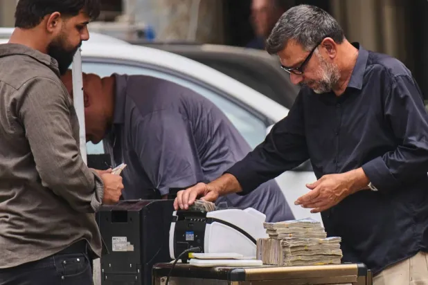 Iraq Devalues Dinar as Citizens Bear the Cost of Fiscal Strain